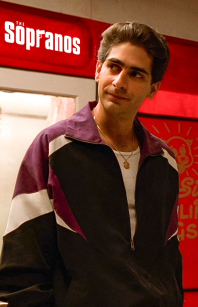 Christopher Moltisanti (Michael Imperioli) de The Sopranos usando um conjunto de tracksuit roxo com regata branca aparecendo e uma corrente de ouro. 