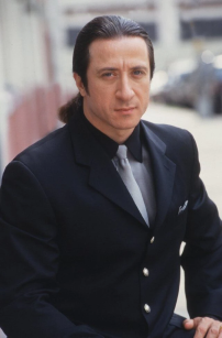 Furio Giunta (Federico Castelluccio) de The Sopranos com o cabelo preso para trás usando um terno meio oversized. 