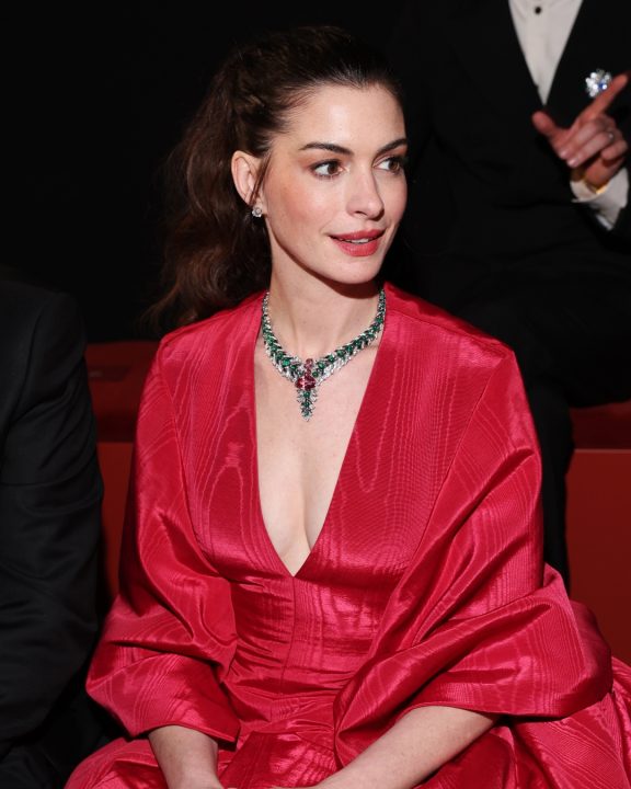 Anne Hathaway impacta em look escultural com vermelho Valentino e esmeraldas Bvlgari