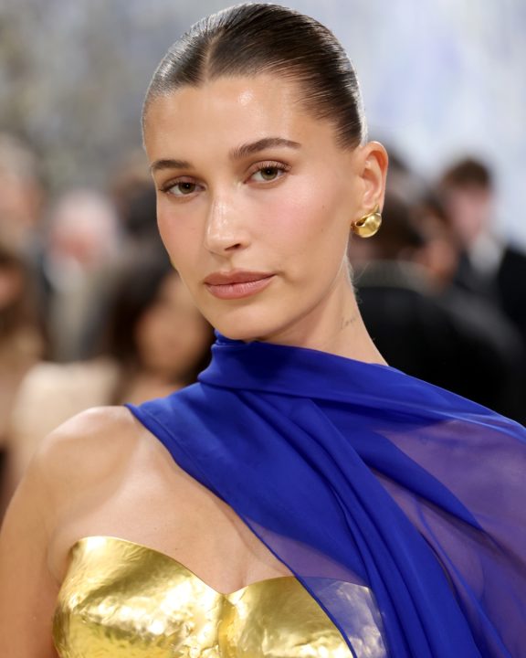 Hailey Bieber aposta em busto metálico e capa fluida em look Balmain no Met Gala 2026