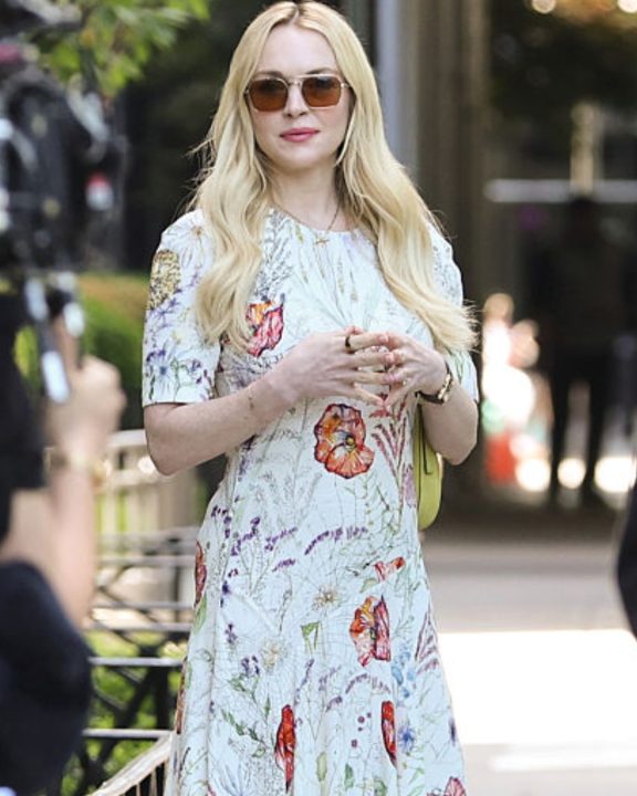 Lindsay Lohan aposta na estampa floral com vestido branco e bolsa de cor tendência